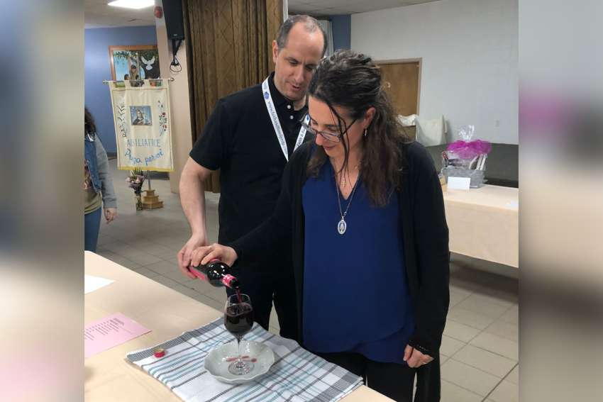 Rosy and David Lombardi, the organizers and coordinators of the marriage preparation program at Maria Ausiliatrice Mission, pour wine into a cup as part of a demonstration exercise of God’s plan of abundance for all.