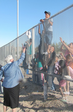 Sister Marie tosses hats over the fence that separates New Mexico and Mexico Oct. 14.