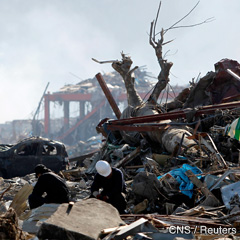 Men sit amid debris in an area that was destroyed by the March 11 earthquake and tsunami, in Minamisanriku, Miyagi prefecture, in northern Japan, April 6. (CNS photo/Toru Hanai, Reuters) 