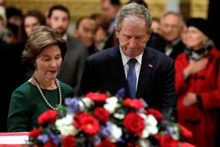 Former U.S. President George W. Bush and former first lady Laura Bush stand at the flag-draped casket of former U.S. President George H.W. Bush as he lies in state inside the U.S. Capitol rotunda Dec. 4 in Washington. George H.W. Bush, the 41st president of the United States, died in his Houston home Nov. 30 at age 94. 