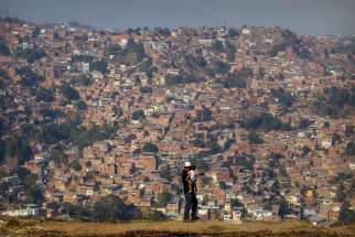  A man and his daughter overlook a neighbourhood in Caracas, Venezuela, March 25. Venezuela&#039;s opposition party hopes Pope Francis will media discussions with the government to find a solution to the country&#039;s deepening economic crisis.
