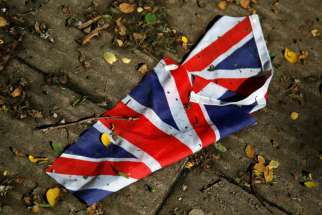 A British flag which was washed away by heavy rains lies on the street in London June 24, 2016 after Britain voted to leave the European Union in the Brexit referendum. 