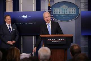 U.S. Health and Human Services Secretary Tom Price gestures at a stack of papers that he said was the Affordable Care Act during a March 7 press briefing as White House Press Secretary Sean Spicer looks on at the White House in Washington. The law, as passed in 2010, was 906 pages long. Republicans in the U.S. House have introduced a measure to repeal and replace the federal health care law.