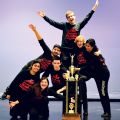 Seven of the nine members of St. Marcellinus’ improvisational team strike a pose with the trophy they brought home after winning the national championships in March.