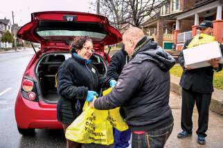  The pandemic has put a spotlight on volunteer efforts in the community. Above, Lorna Bahamondes delivers groceries on behalf of the Society of St. Vincent de Paul.