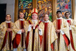 Cardinal Thomas Collins, staff in hand, stands tall with five freshly ordained priests for the Toronto archdiocese, left to right, Antonello Murgia, Matthew McCarthy, Jeremias Inoc, brothers Ryan Alemao and Favin Alemao.