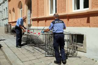 Two police officers set up a barrier in front of a building June 28 after a fire destroyed a reception center for asylum seekers in Meissen, Germany. Cardinal Reinhard Marx of Munich-Freising, president of German bishops&#039; conference, said an attack July 16 in the Bavarian town of Reichertshofen revealed that &quot;some groups&quot; were trying to &quot;sow hatred&quot; against migrants.