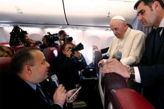 Pope Francis listens to a question from Romanian journalist Cristian Micaci aboard his flight from Sibiu, Romania, to Rome June 2.