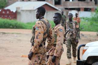 South Sudanese policemen and soldiers stand guard along a street following renewed fighting July 10 in Juba. Pope Francis have send a high-ranking cardinal to the war-torn country to urge peace.
