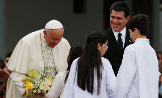 Pope Francis receives flowers at Silvio Pettirossi International Airport in Asuncion, Paraguay, July 10. 