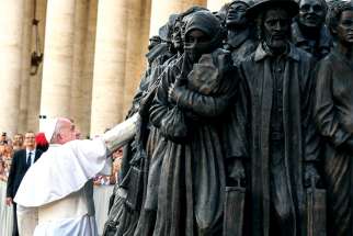 Pope Francis touches the piece after overseeing its unveiling in St. Peter’s Square on Sept. 29.