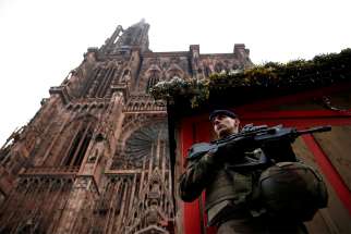A French soldier stands guard near a closed wooden barrack shop at the traditional Christkindelsmaerik (Christ Child market) in front of the Cathedral of Our Lady of Strasbourg Dec.12, the day after a shooting. At least two people were killed while one person was left brain dead and at least a dozen others were injured after a gunman attacked the market Dec. 11, authorities said. 