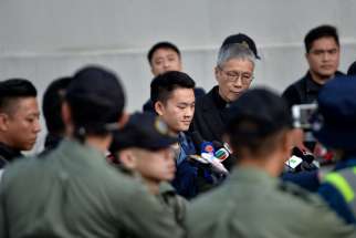 Chan Tong-kai, 20, center, whose case led to plans to change Hong Kong extradition rules, is released and accompanied by Anglican Father Peter Koon Ho-ming at Pik Uk Prison in Hong Kong Oct.23, 2019.