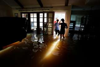 A family that wanted to remain anonymous moves belongings from their home Aug. 31 that was flooded by Tropical Storm Harvey in Houston. 