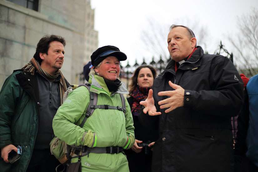 American pilgrim Ann Sieben is greeted outside the Basilica-Cathedral Notre-Dame in Quebec City by its rector, Msgr. Denis Belanger, on Holy Thursday, March 24.