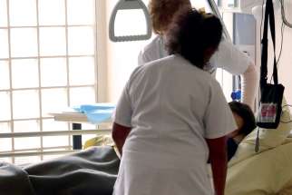 Nurses provide care to a patient at the palliative care unit of a hospital.