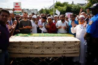 A crowd of community members pray next to the coffins as they gather for the funeral service of Imam Maulama Akonjee in the Queens borough of New York City, on August 15, 2016.