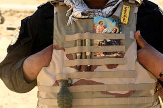 A Christian fighter displays a holy card in his vest Nov. 2016 in Mosul, Iraq.