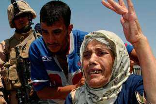 An elderly Iraqi woman fleeing violence gestures at the Al Waleed refugee camp in Iraq Aug. 19. One group of sick, elderly Iraqi Christians said they defied terrorist demands to convert to Islam or be killed.