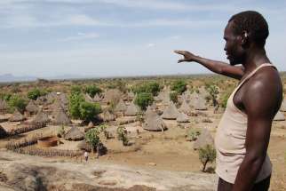 A man points at a village in rural South Sudan before the civil war. Most of the villages have been destroyed in the war. 