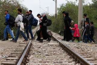 Refugees cross train tracks into Macedonia after arriving at a transit camp in Idomeni, Greece, Oct. 19. Thousands of refugees are arriving into Greece from Syria, Afghanistan, Iraq and other countries and then traveling further into Europe.