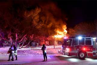 Residents of Cedar Crest Drive in Abilene, Texas, walk past their burning house Feb. 15, 2021, as firefighters fight the blaze. The firefighters were only able to draw water from one hydrant because all three city water treatment plants were offline due to cold weather power outages.