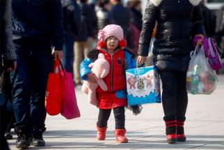 A young girl carrying a stuffed toy holds on to her mother&#039;s hand in 2013 as they walk outside the train station in Beijing. China&#039;s Communist Party leaders announced they would change the nation&#039;s one-child policy, which most strictly applied to Han Chinese living in urban areas of the country. 