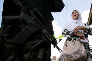  A Filipino woman speaks to a soldier at a checkpoint in Marawi, Philippines, June 1, 2017. Catholic bishops in the southern Philippines supported the declaration of martial law in Mindanao following an attempt by a band of gunmen claiming to be Islamic militants to seize the city.