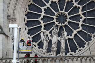 Firefighters inspect one of the rosette windows of Notre Dame Cathedral April 16, 2019, after a fire broke out in the iconic Paris structure. Officials said the cause was not clear, but that the April 15 blaze could be linked to renovation work. 