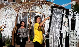 Callie Connors, assistant to local artist Meg Saligman, works to string of prayer intentions on the makeshift walls of the Knotted Grotto outside Philadelphia&#039;s Cathedral Basilica of SS. Peter and Paul. Thousands of visitors have added their prayers to the project during the World Meeting of Families 2015.