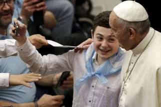 A child takes a selfie with Pope Francis. The Holy Father’s willingness to be open and accessible is one of the ways, that Francis has proven that he is “real” as Robert Brehl summarizes.