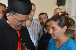 Lebanese Cardinal Bechara Rai, Maronite patriarch, who headed a delegation of Mideast patriarchs, blesses a baby Aug. 20 in Irbil, Iraq. The blessing took place in one of the churches housing the more than 100,000 Christians and minorities displaced in t he country by the advance of Islamist militants.
