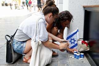 Israelis light candles near the site of a Palestinian shooting attack in Tel Aviv, Israel, June 9, 2016. 