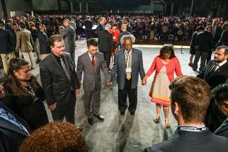 Southern Baptist Convention leaders pray together on the stage during the National Call to Prayer for Spiritual Leadership, Revived Churches and Nationwide and Global Awakening during the annual meeting of the Southern Baptist Convention on Tuesday, June 14, in St. Louis.