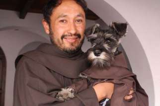 Friar Carmelo the dog with Franciscan Friar Jorge Fernandez in Cochabamba, Bolivia.
