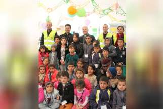 Displaced Iraqi Yezidi children greet Catholic Relief Service workers and a delegation of the U.S. Conference of Catholic Bishops, led by Bishop Oscar Cantu during a visit to Shariah Collective, Iraq, Jan. 17. 