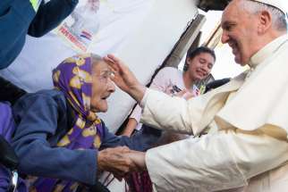 Pope Francis greets an elderly woman as he meets with people of the Banado Norte neighborhood in Asuncion, Paraguay, in this July 12, 2015, file photo. On Dec. 16, 2019, the eve of his 83rd birthday, Pope Francis met with a group of his peers, although many were a few years younger, and told them that &quot;old age is a time of grace.&quot;