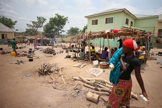 A woman carries a child through a camp in the state of Benue, Nigeria, April 11. The Catholic Diocese of Makurdi and others condemned the killings of two priests and 17 parishioners of St. Ignatius Catholic Church in the state.