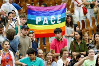 Young people hold a flag reading &quot;peace&quot; in Italian at the end of Pope Francis’s weekly general audience in the Paul VI Audience Hall at the Vatican Aug. 23, 2023.