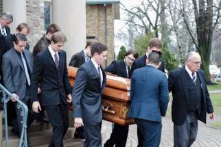 Pallbearer&#039;s carry Joanne McGarry&#039;s casket out of the Our Lady of Perpetual Help Church following her May 1 funeral. 