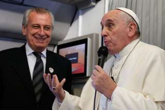 Pope Francis refers to Alberto Gasparri, left, papal trip planner, while answering a question from a French journalist aboard his flight to Manila, Philippines, Jan. 15.