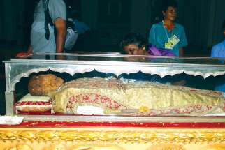 Pilgrims pray by and view the body of St. Francis Xavier during an exposition of the saint in December 2004 at the Se Cathedral in Goa, India.