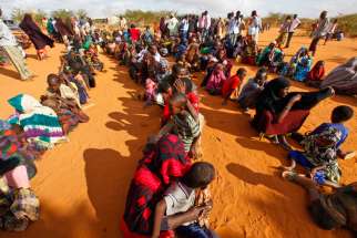 Refugees who fled the famine in Somalia wait in a reception area in 2011 at a camp in Dadaab, Kenya. Bishop Joseph Alessandro of the Garissa Diocese and the Jesuit Refugee Service are concerned about closing down the refugee camp with proper care.