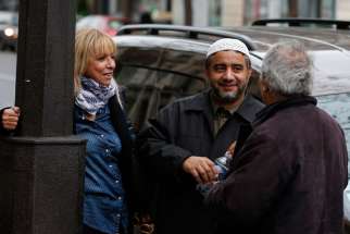Abdelali Mamoun, an imam in Paris, talks with people on the street near the Bataclan music hall in Paris Nov. 16. About a dozen imams in the city showed up at a memorial near Bataclan, where about 100 people were killed in the Nov. 13 terrorist attacks by the Islamic State.