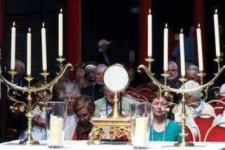 People adore the Eucharist during Mass.