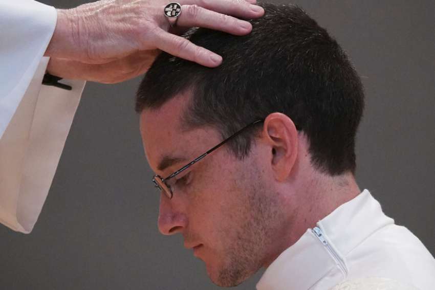 Bishop David P. Talley of Memphis, Tenn., puts his hands on newly ordained priest Father Joseph Hastings at Immaculate Conception Catholic Church June 13, 2020.