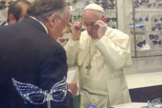 Pope Francis tries on a pair of glasses in an optical store in downtown Rome Sept. 3. Romans and tourists crowded outside the shop to catch a glimpse of the pope inside as he had his eyes measured for a new set of bifocal lenses. 