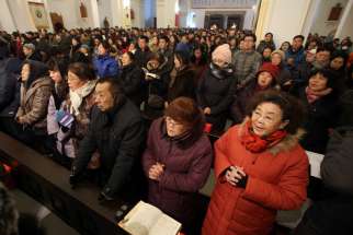 People pray during a 2013 Mass in Qingdao, China. Catholic experts have warned that new rules on religion in China could severely hamper the church&#039;s work.