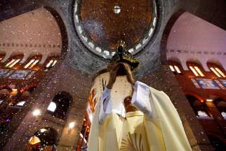 A priest holds an image of Our Lady of Aparecida during a Mass in Brazil&#039;s Basilica of the National Shrine of Our Lady of Aparecida Oct. 11, 2011. Pope Francis has declined Brazil president Michael Temer’s invitation to visit for the 300th anniversary of the Marian apparition.