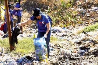 A volunteer picks up trash at Freedom Island, a marshland considered to be a sanctuary for birds, fish and mangroves in a coastal area of Las Pinas City, near Manila, Philippines. Few papal encyclicals have been as eagerly awaited as Pope Francis’ upcoming statement on the environment.